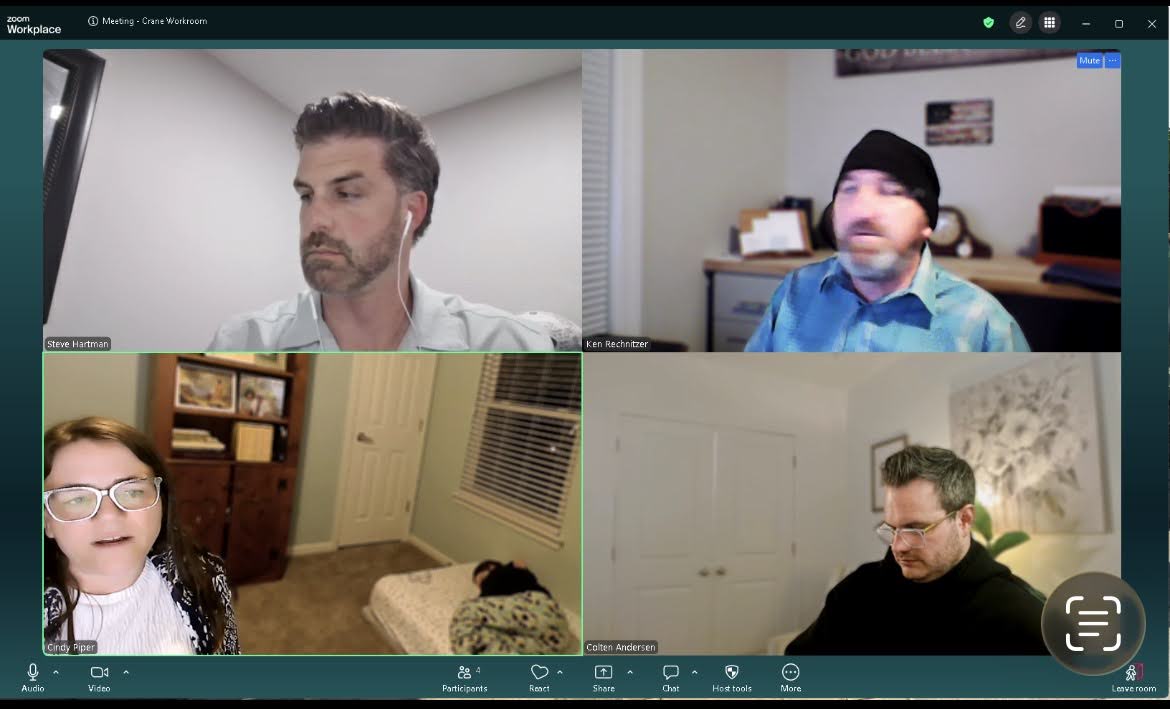 Four people participating in a video call, each in separate frames, with neutral backgrounds.