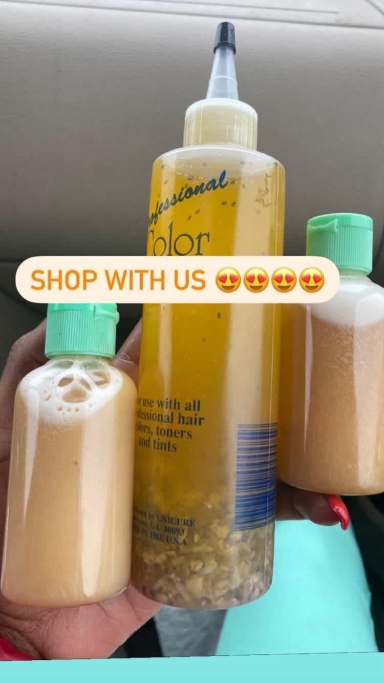 Three bottles, one with a yellow liquid and a nozzle, two with beige liquids and green caps, held in hand.