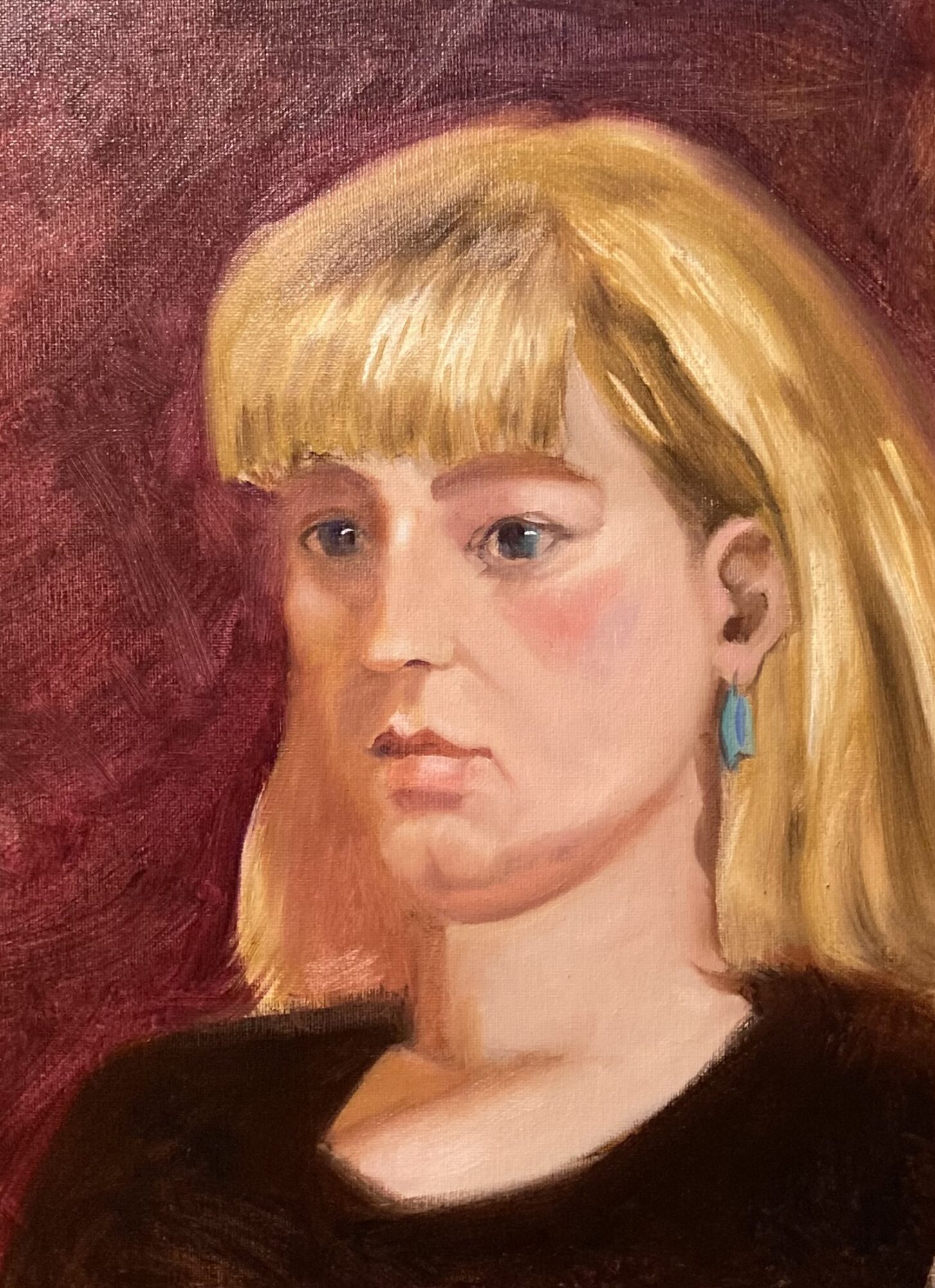 Portrait of a young woman with blonde hair, wearing a black top and blue earrings, against a red background.