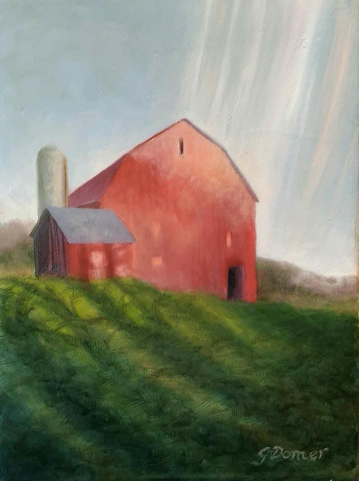 A red barn with a smaller attached structure on a grassy hill, with a silo in the background and sunlight streaming down.