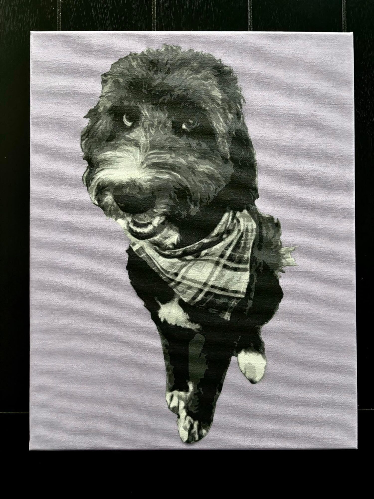Black and white photo of a dog wearing a bandana, facing forward with a happy expression.