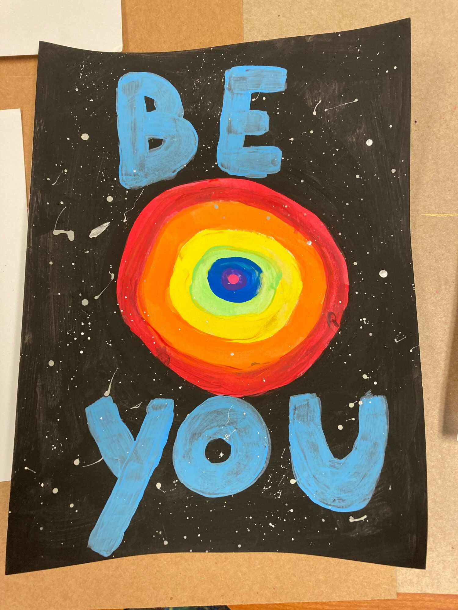 Poster with the words 'BE YOU' and a colorful concentric circle design on a black background.