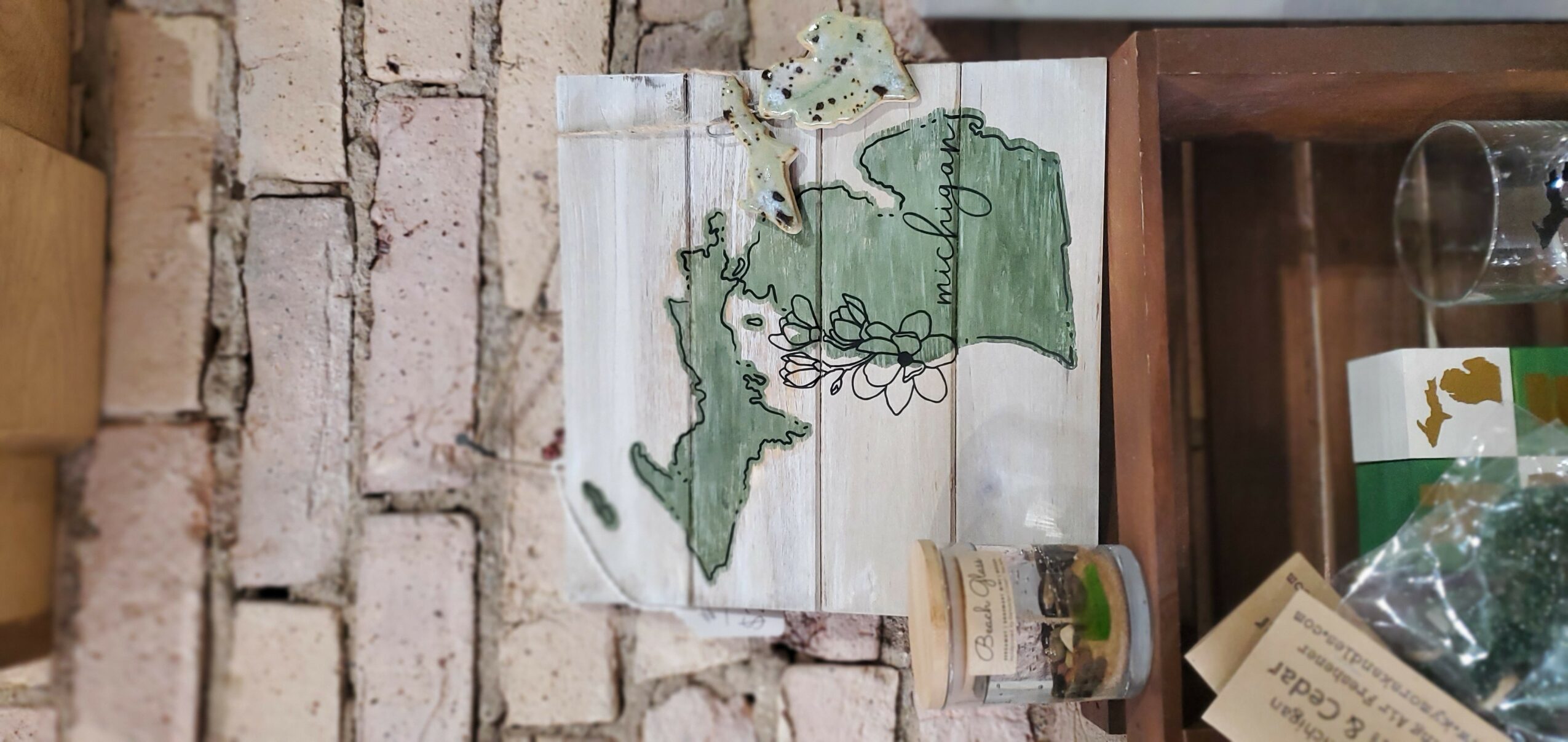 A wooden board with a map of Ireland and a decorative tree, placed on a brick wall background.