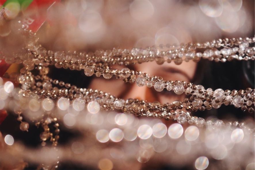 Close-up of sparkling jewelry with beads and crystals, with a blurred background and bokeh effect.