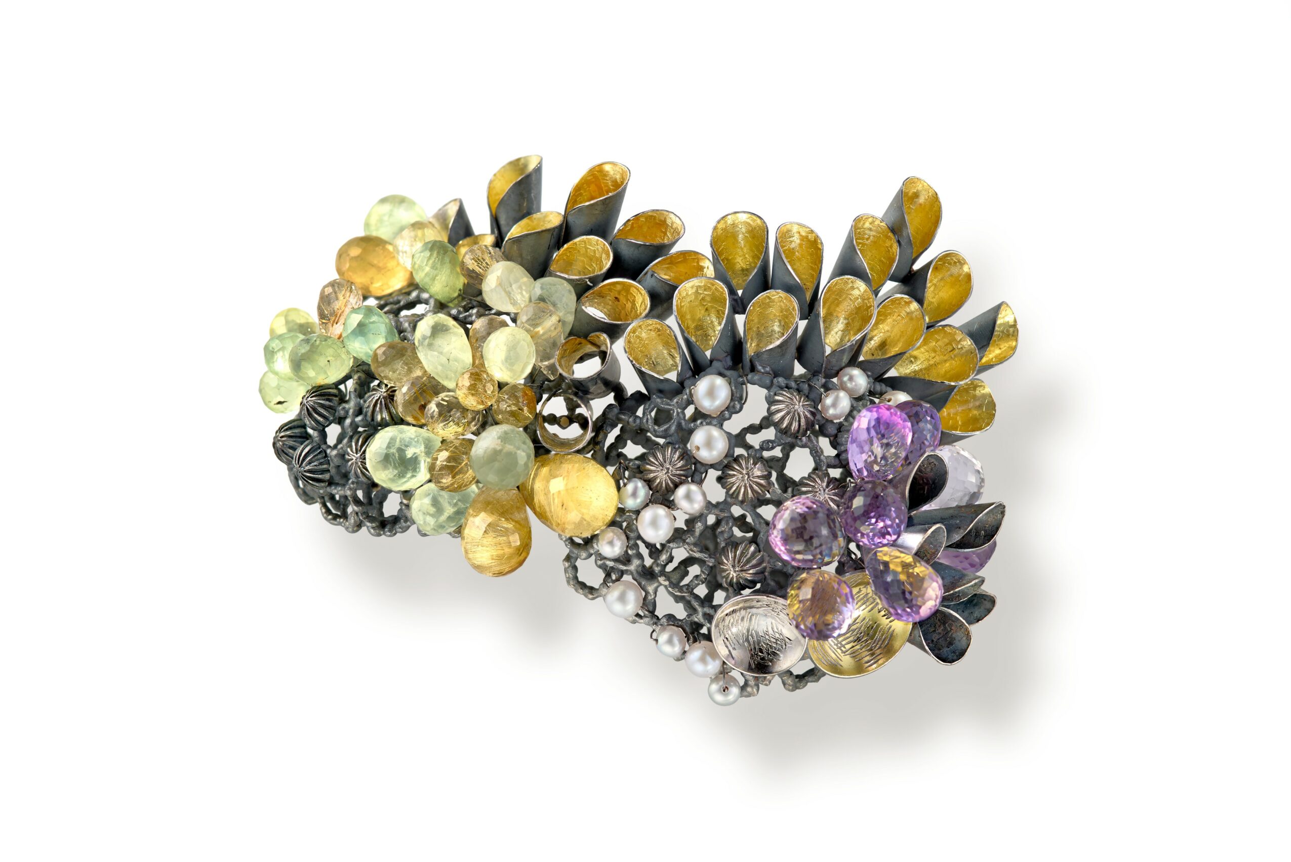 Decorative brooch with multicolored gemstones and floral design, featuring yellow, purple, black, and clear stones.