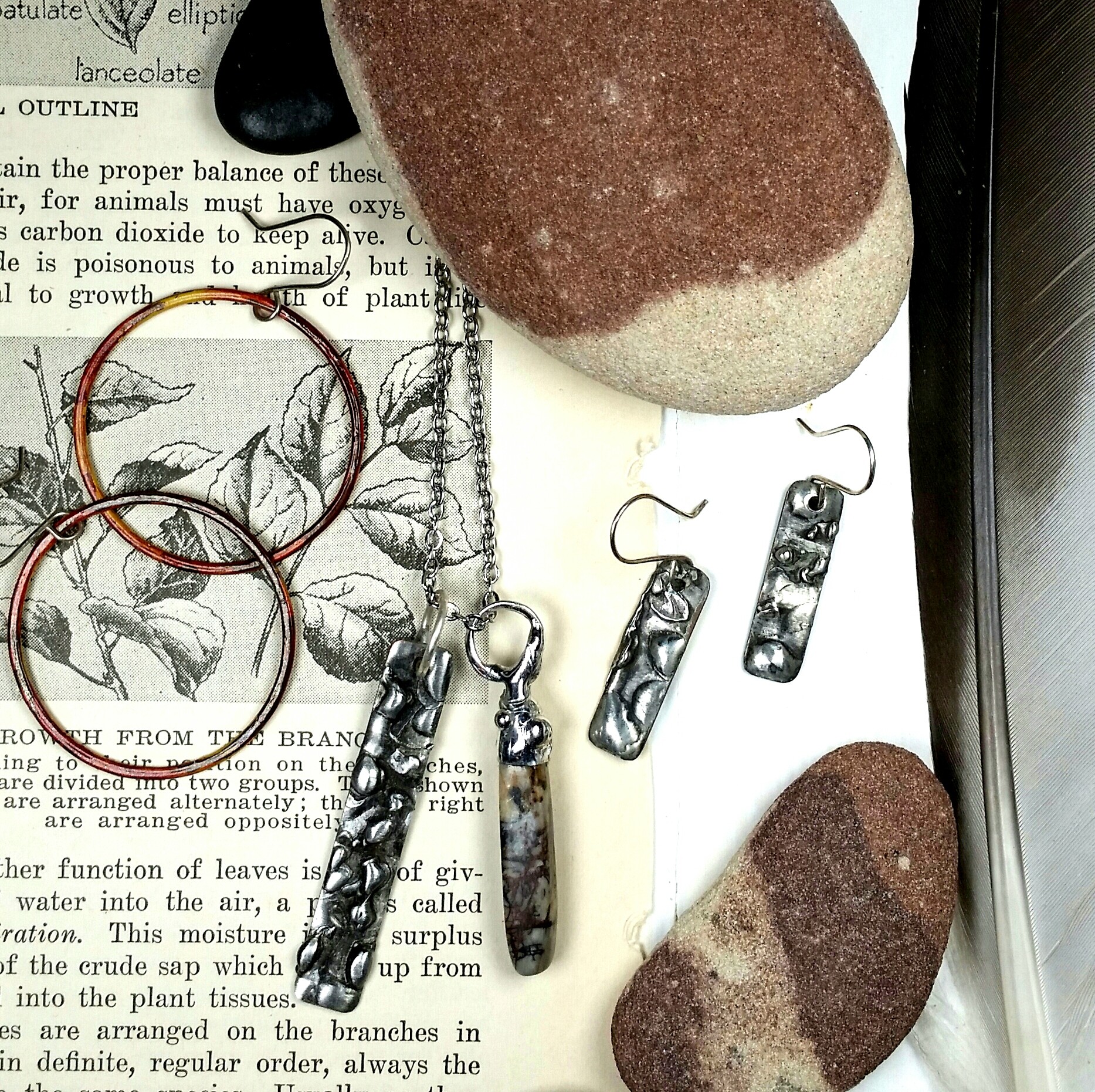 A collection of jewelry, a rock, and a chain on a page with text and illustrations.