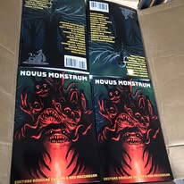 Four boxes of a product with dark and red artwork, two with visible text, placed on a tiled floor.