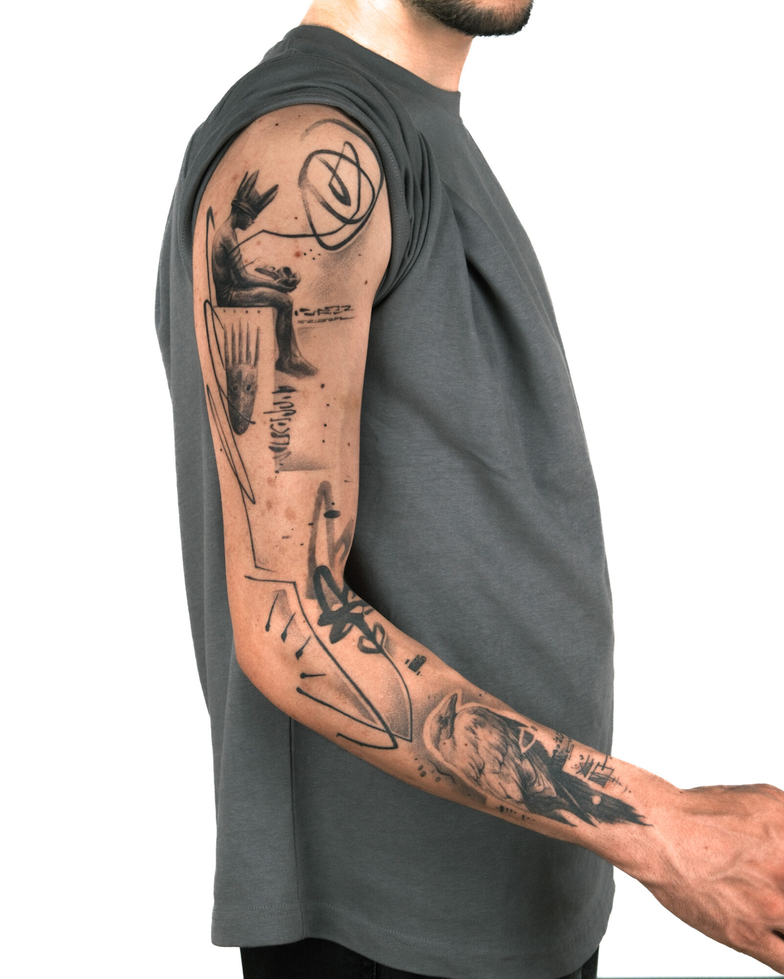 Side view of a person with tattoos on arm, wearing a sleeveless shirt, facing right.