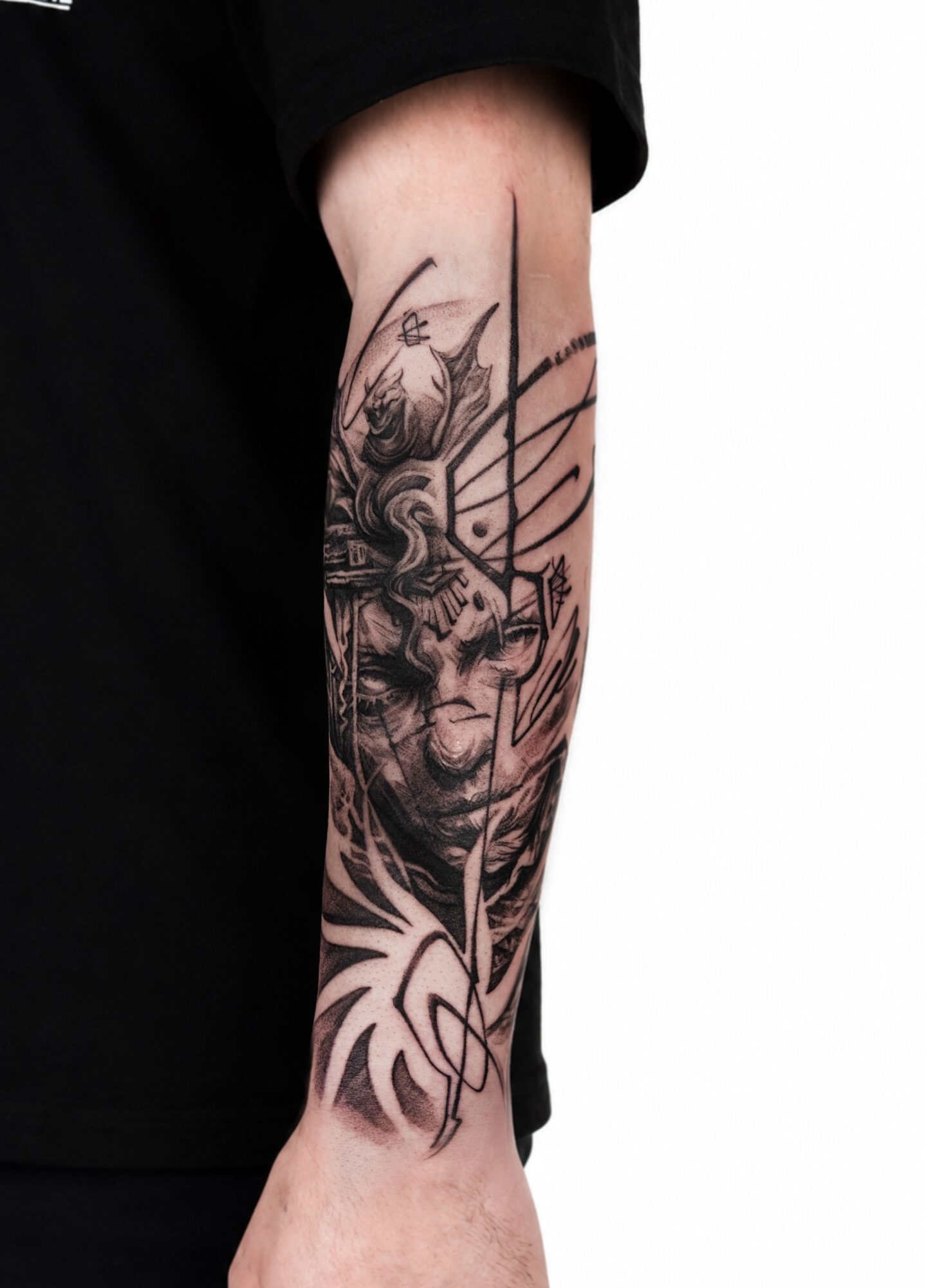Tattoo of a dragon and abstract design on person's forearm, black ink, detailed line work.