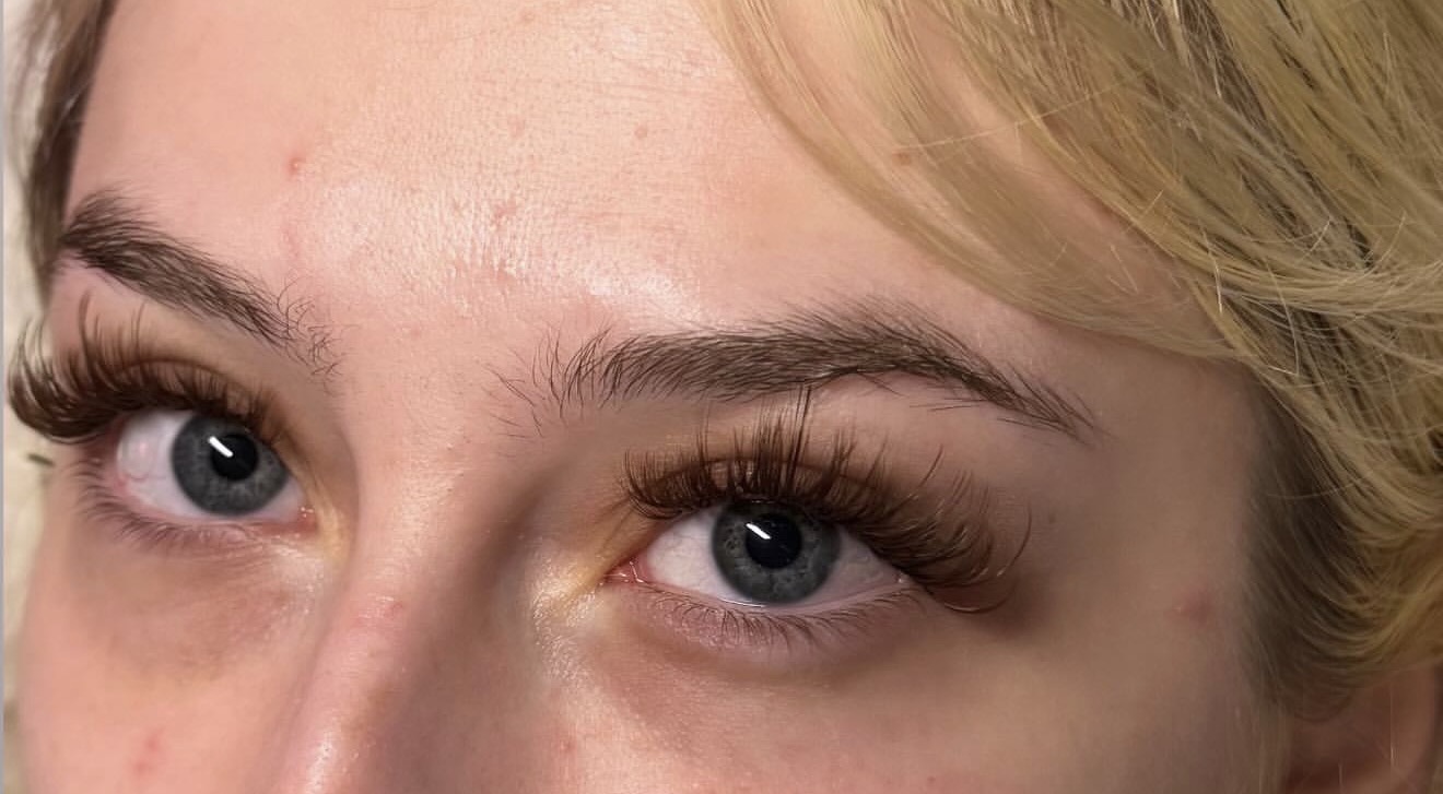 Close-up of a person's eyes and eyebrows with makeup and visible skin texture.