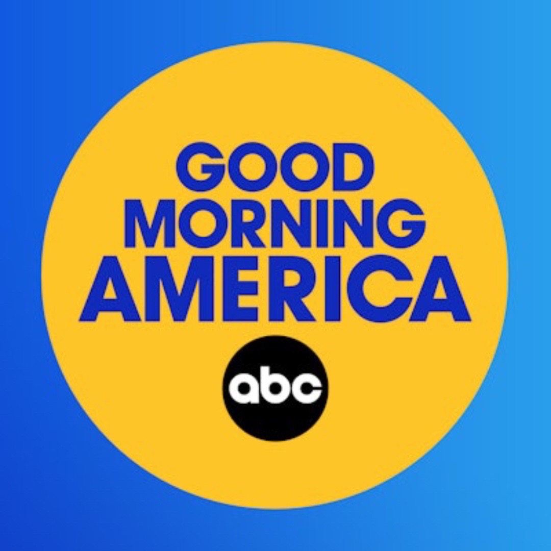 Yellow circle with blue text reading 'Good Morning America' and a black circle with 'abc' logo, on a blue background.