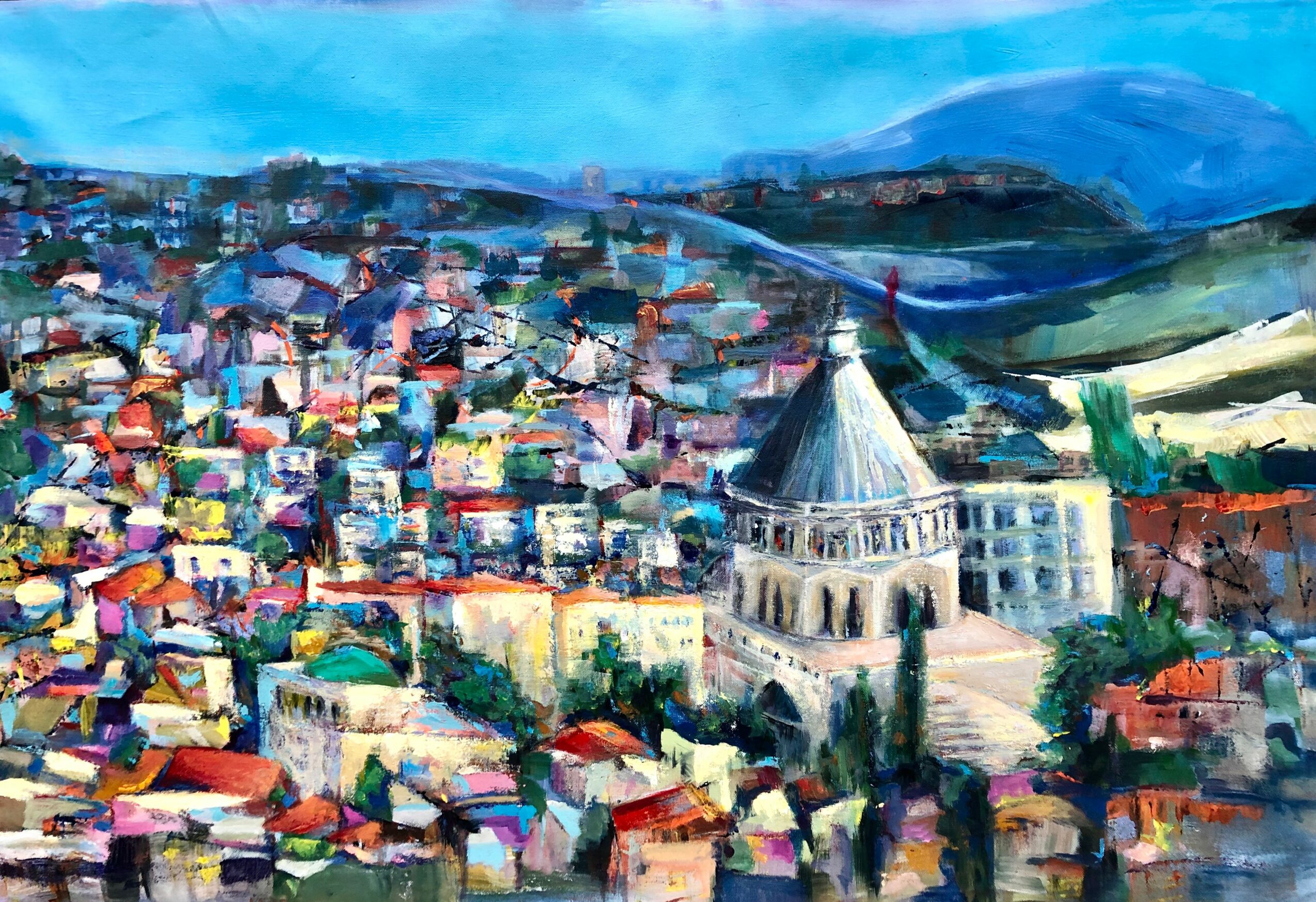 Colorful cityscape with a prominent domed building, hills in the background, and a bright blue sky.