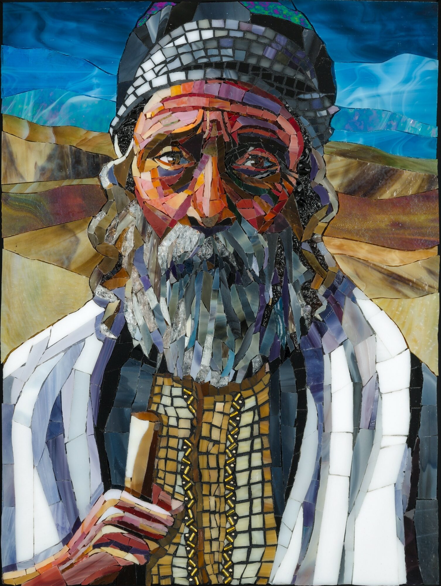 Portrait of an elderly man with a beard, wearing a head covering and traditional clothing, holding a staff, landscape background