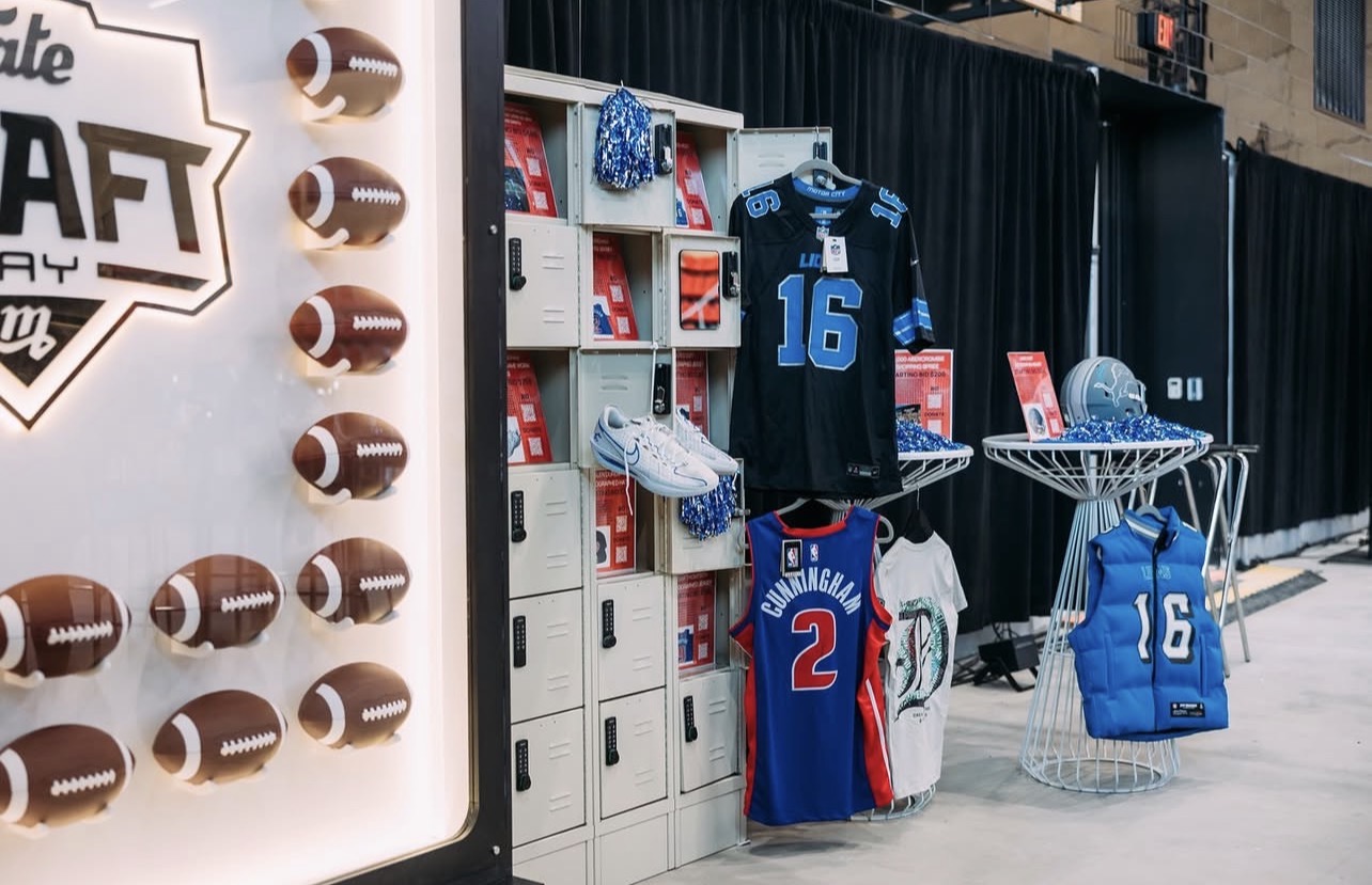 Display of football jerseys, bags, and lockers at an event with football-themed decorations.