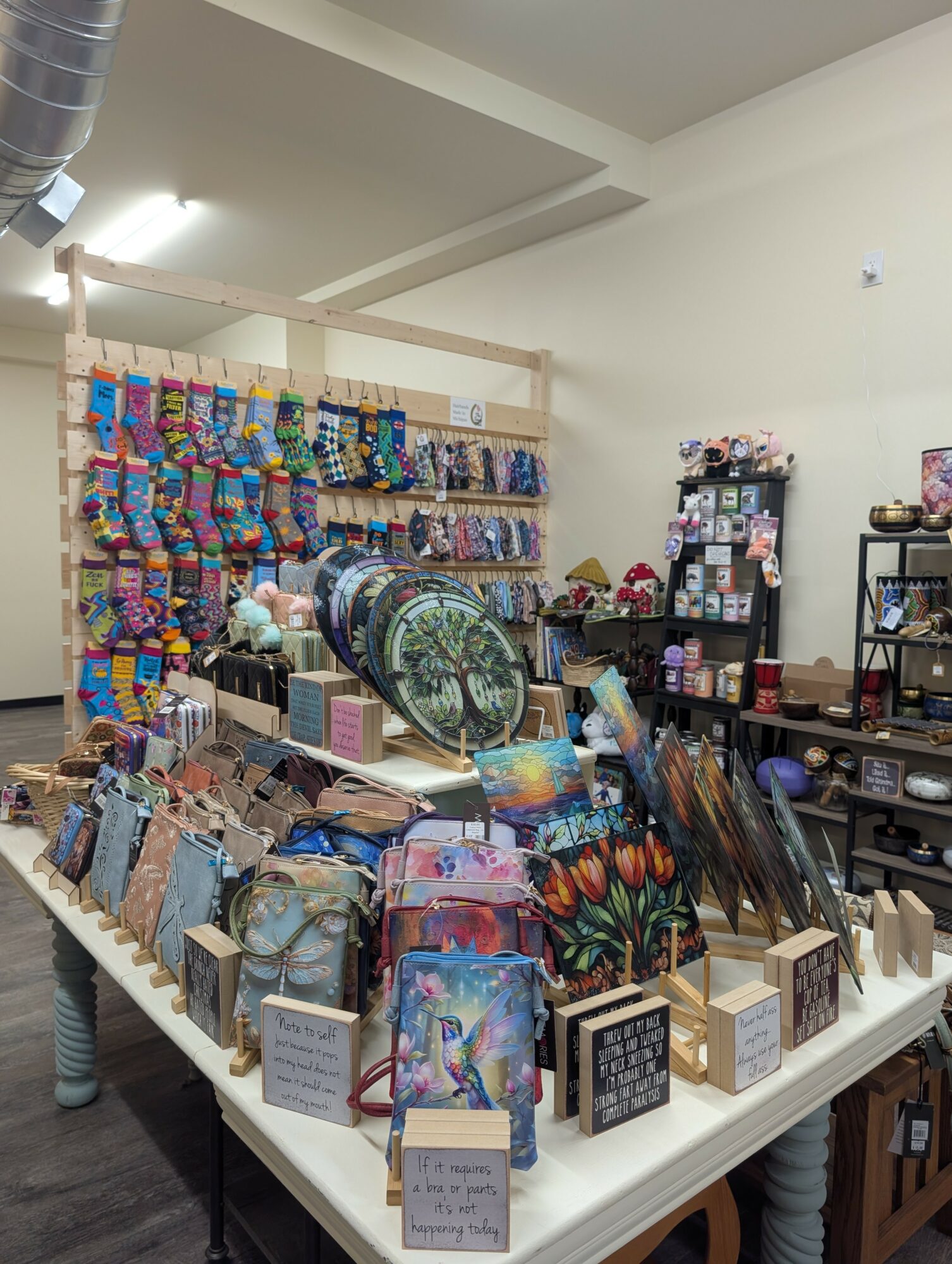 Display of colorful accessories, jewelry, and decorative items on tables and shelves in a store interior.