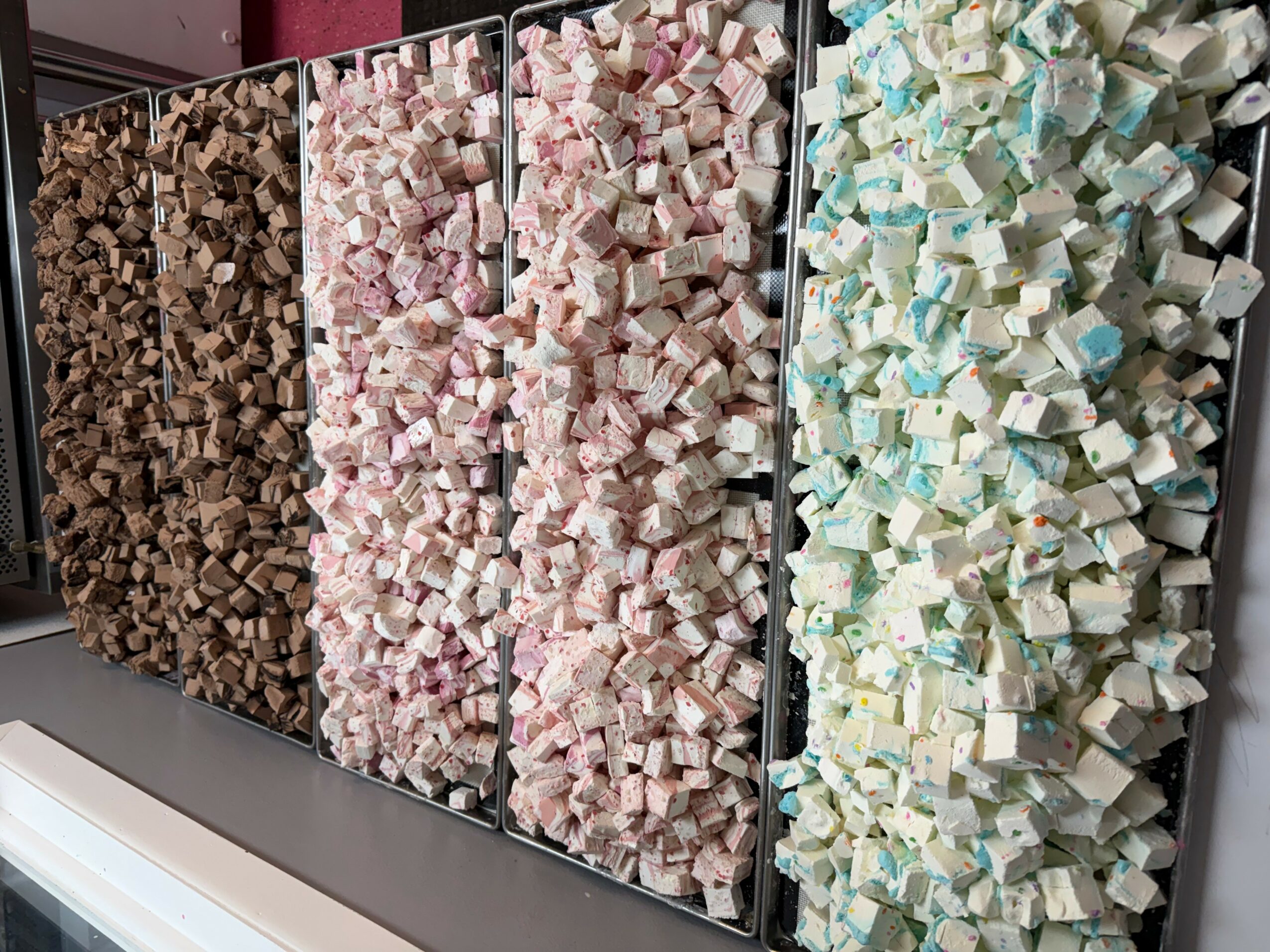 Four vertical panels filled with small, colorful cubes in shades of brown, pink, light blue, and white.