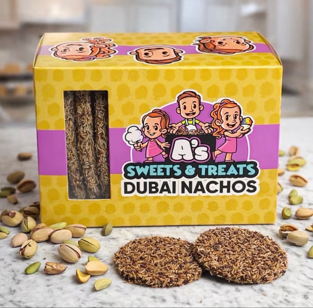 Box of Dubai Nachos sweets and treats with two round snacks and scattered pistachios in front.