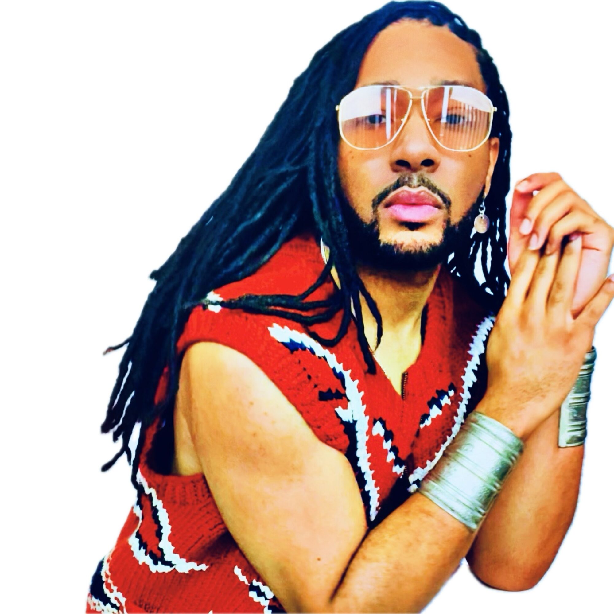 Person with long dreadlocks, wearing sunglasses, a red patterned sleeveless top, and metallic bracelets, posing with hands together.