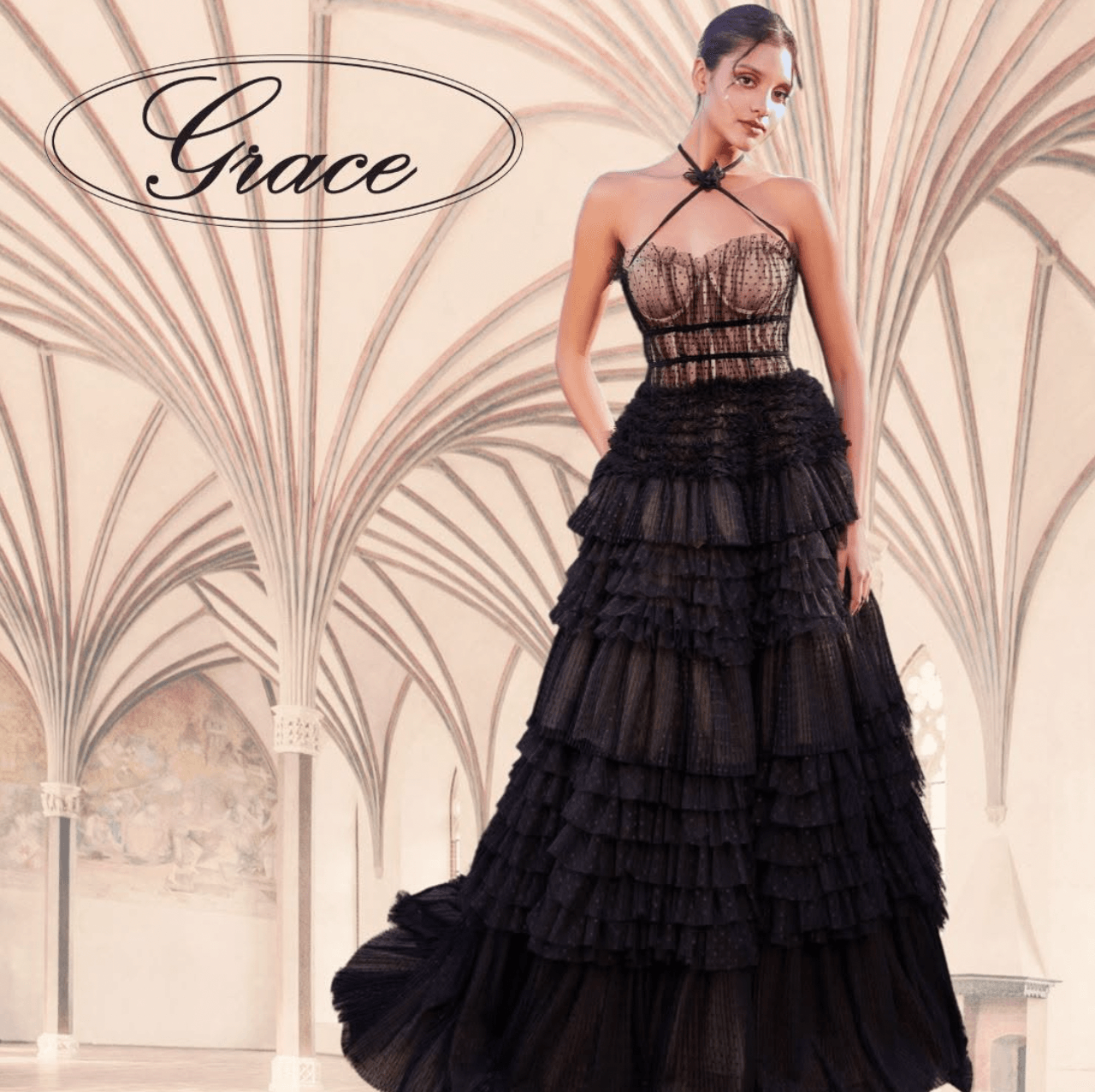 Woman in a black tiered dress standing in a grand architectural setting with arches.