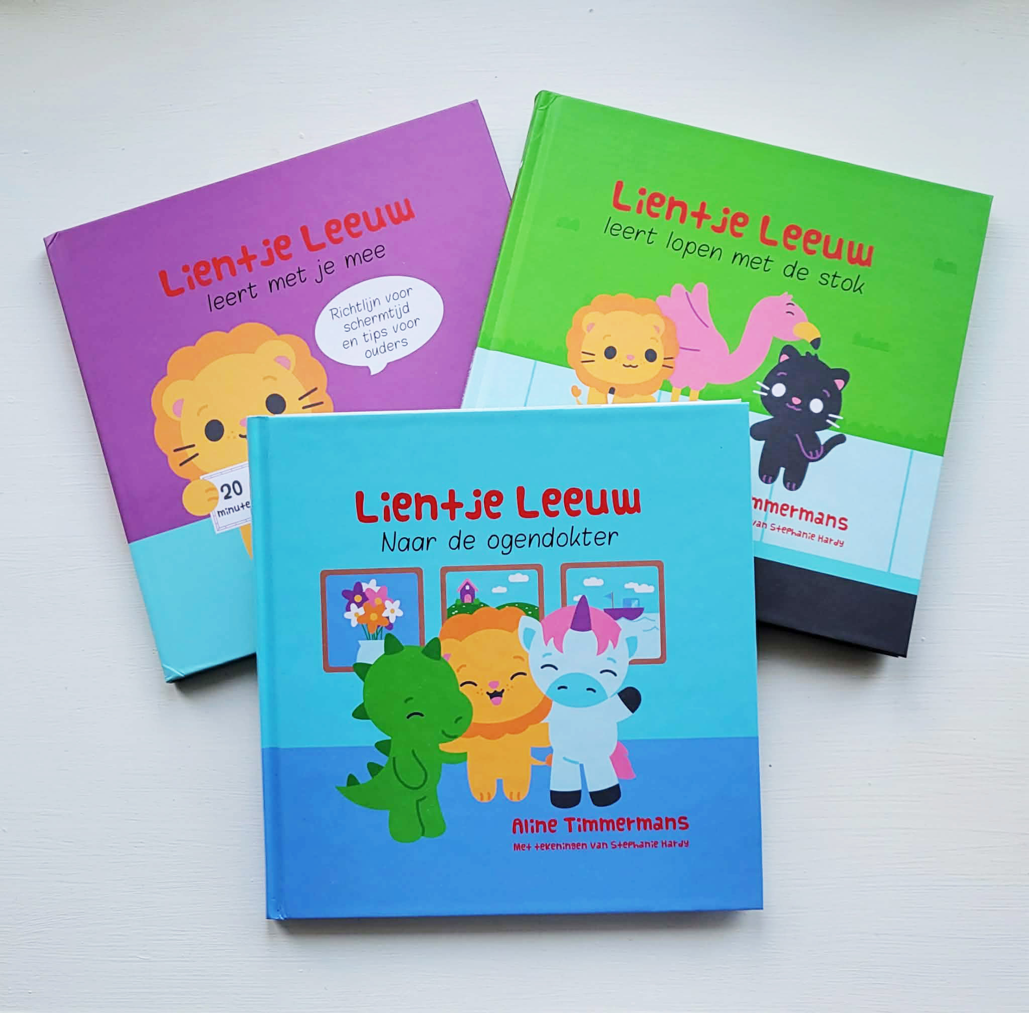 Three children's books with colorful covers featuring animals and children, arranged on a white surface.