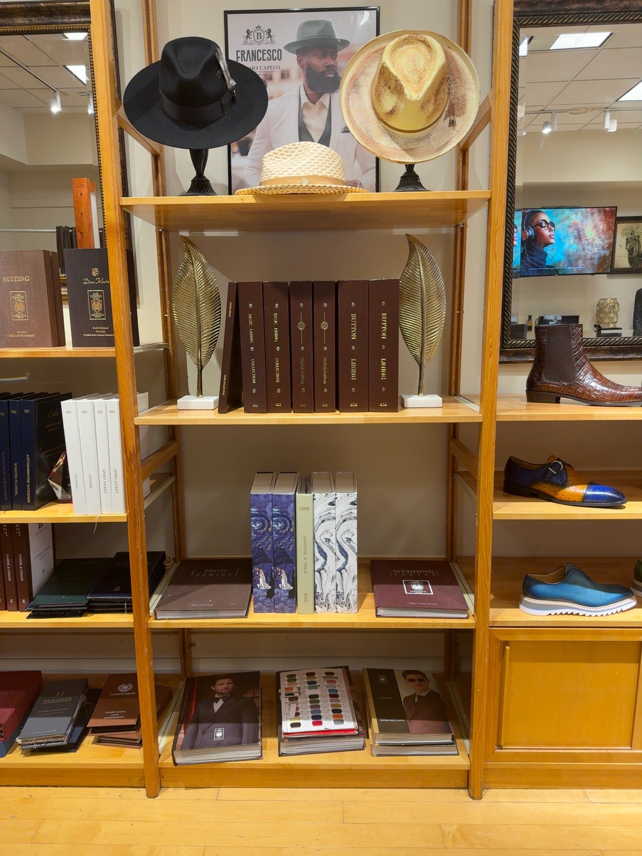 Wooden shelf with hats, books, and decorative items, in a store setting.