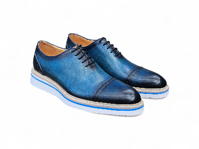 Pair of blue and black leather dress shoes with white soles, viewed from the side.