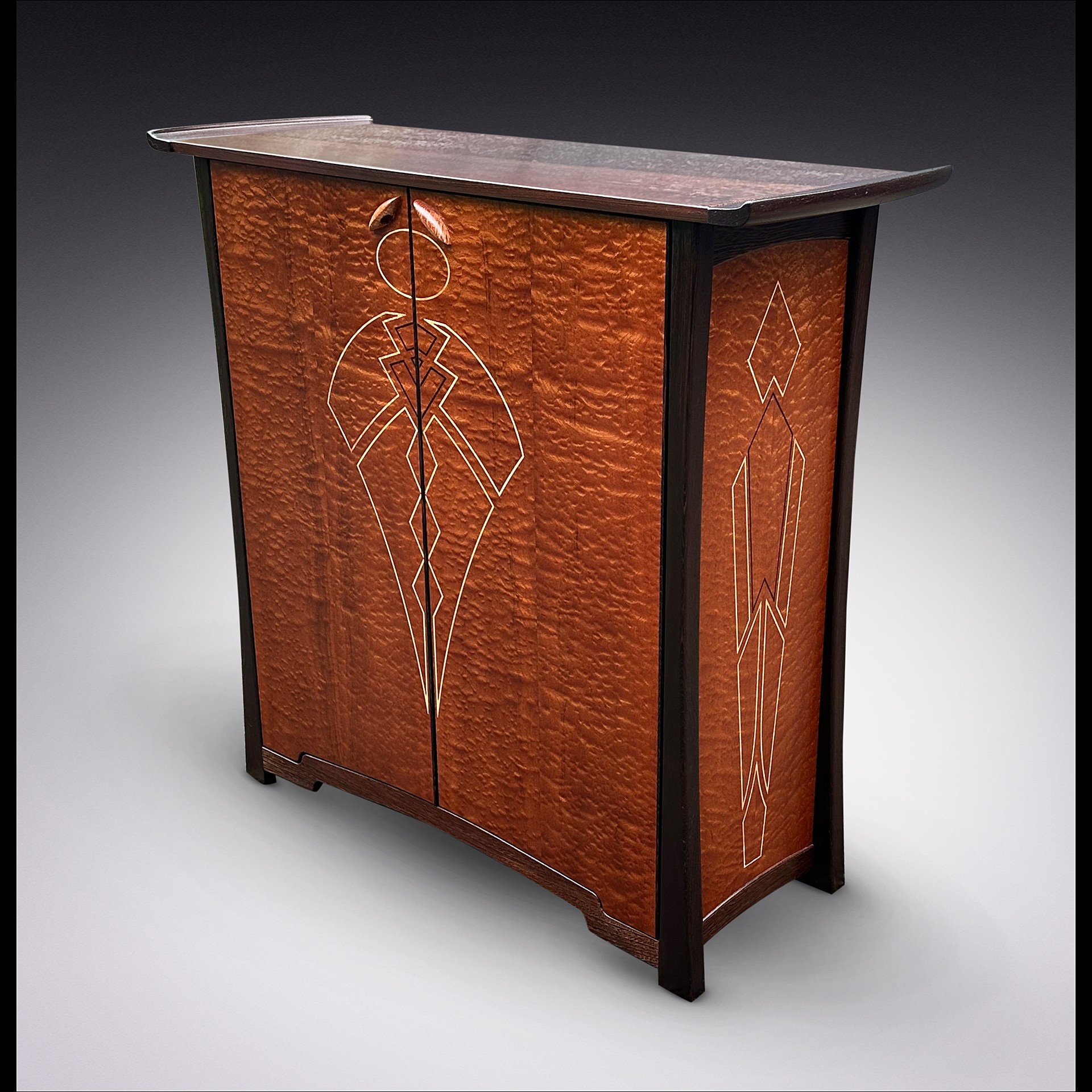 Wooden cabinet with geometric inlay designs on doors and sides, topped with a flat surface, against a dark background.