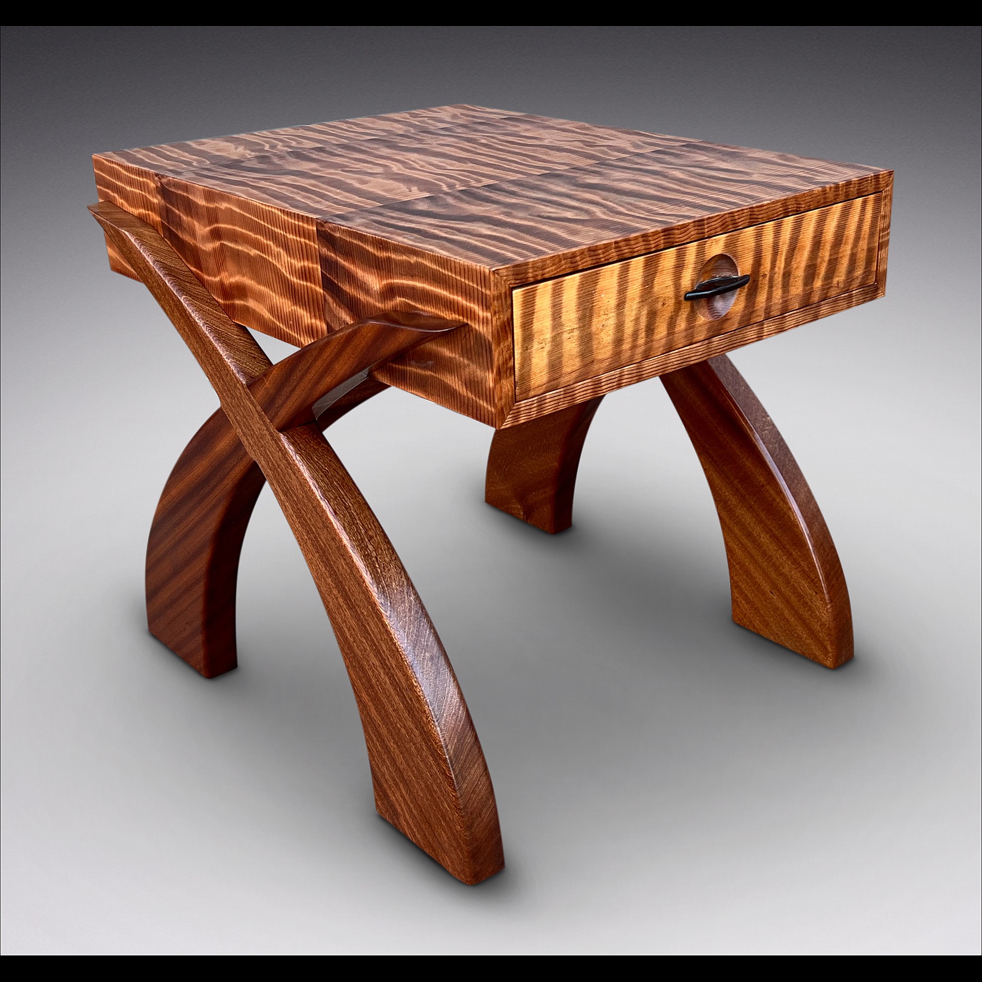 Wooden table with a square top and curved legs, featuring a small drawer with a handle.