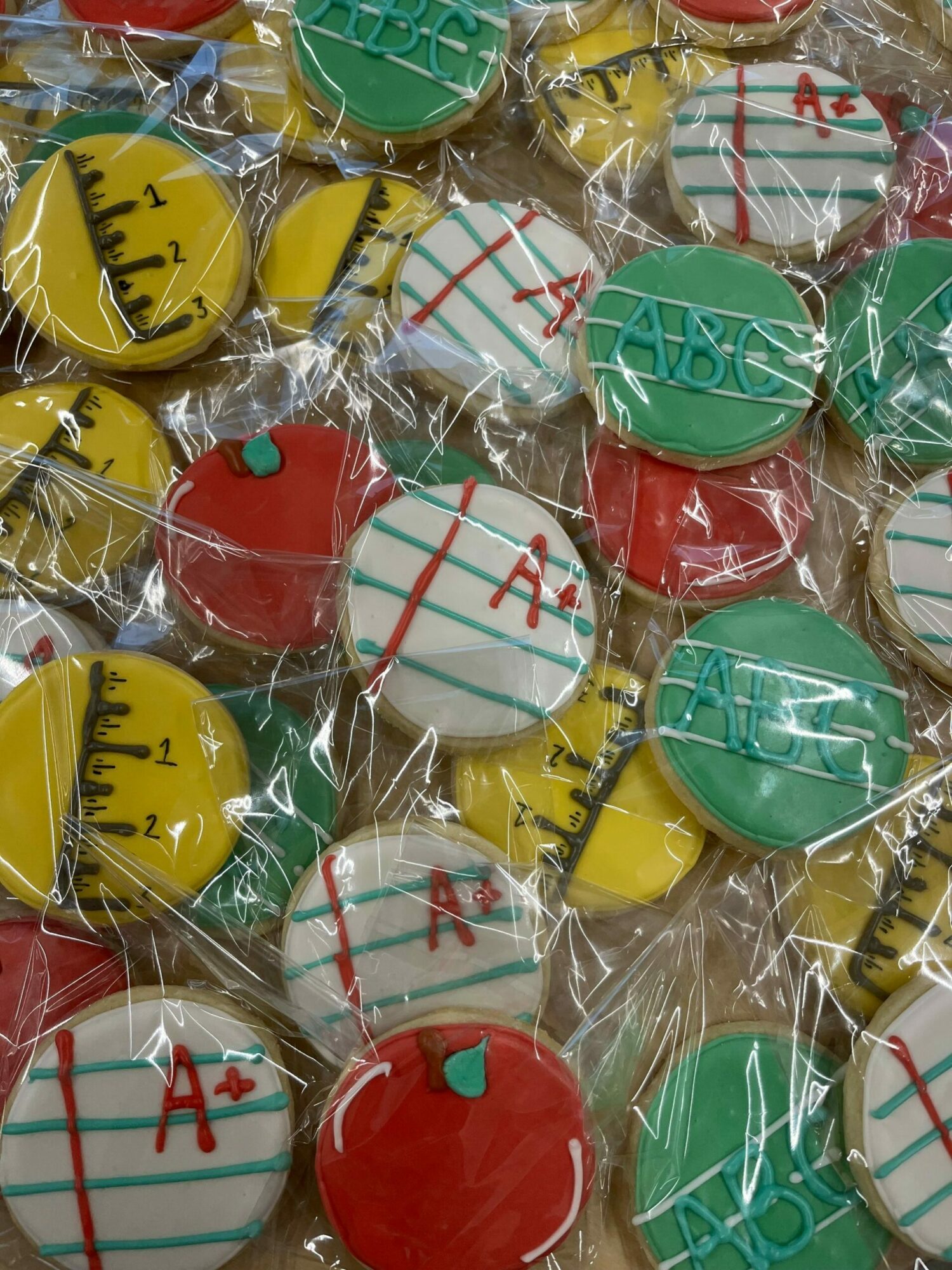 Colorful cookies wrapped in clear plastic, decorated with various patterns and colors including red, green, yellow, and white.