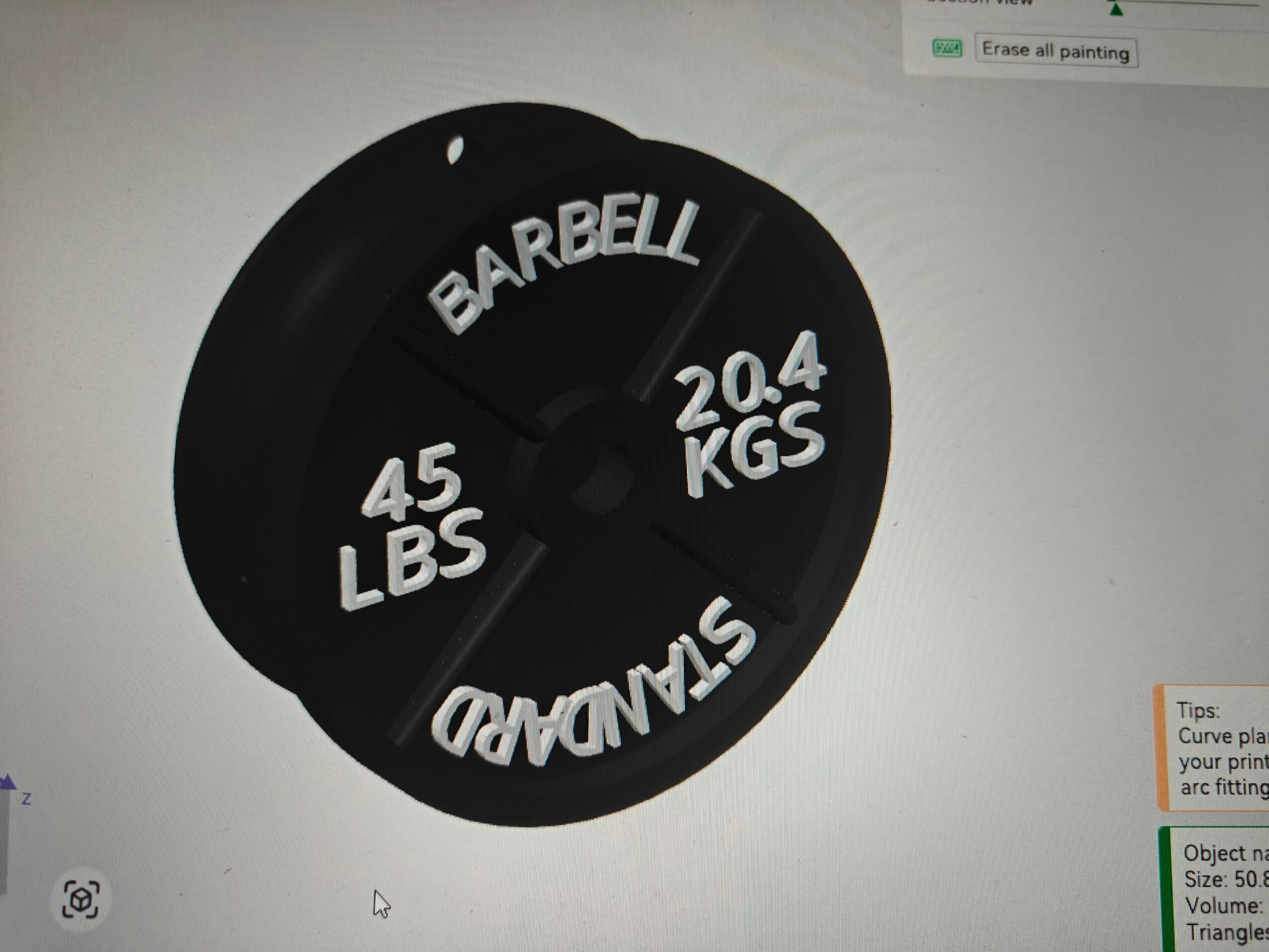 Black weight plate with white text displaying weight in pounds and kilograms, and brand name, on a white surface.