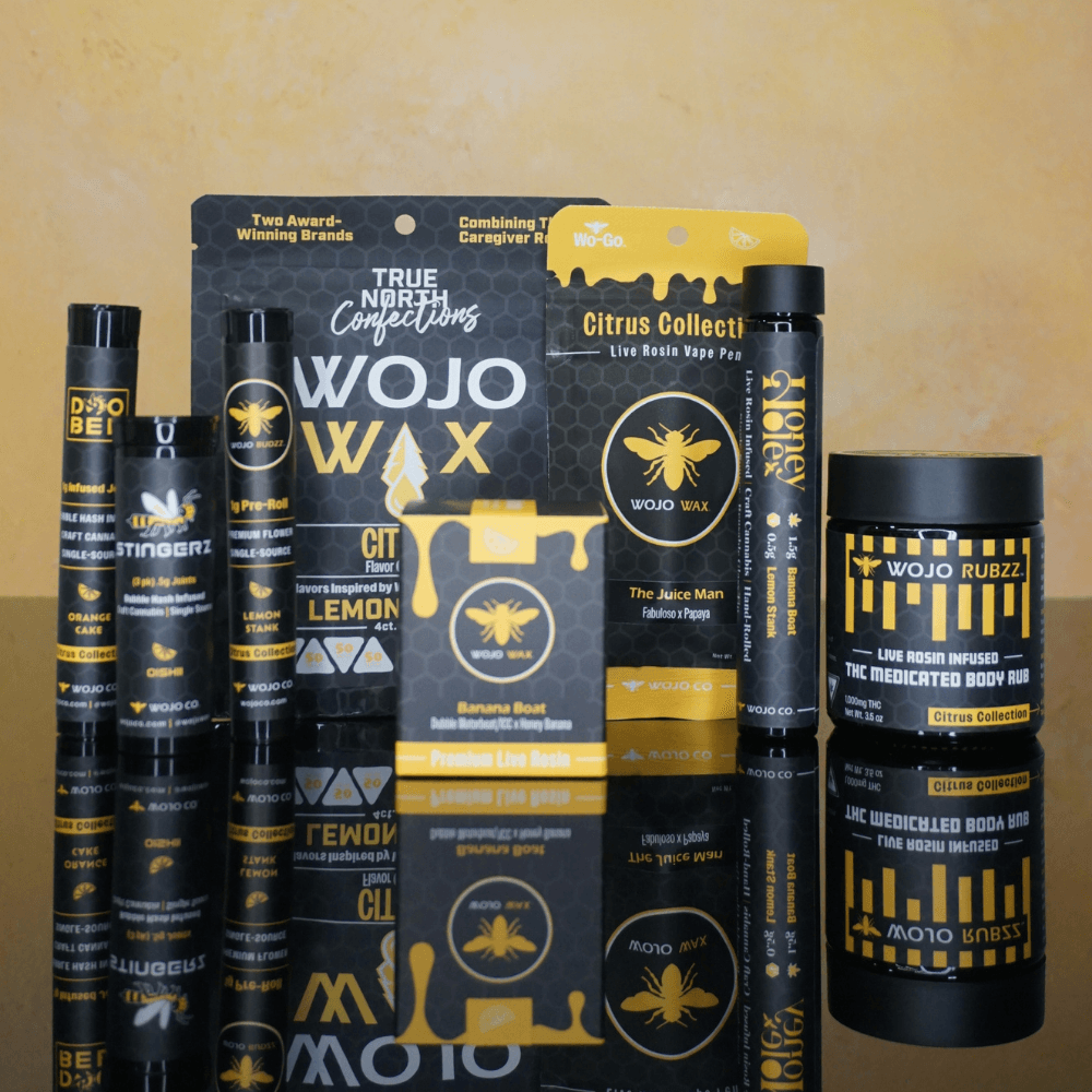 Collection of black and yellow cannabis-themed products, including containers, tubes, and packaging with bee and honeycomb designs.