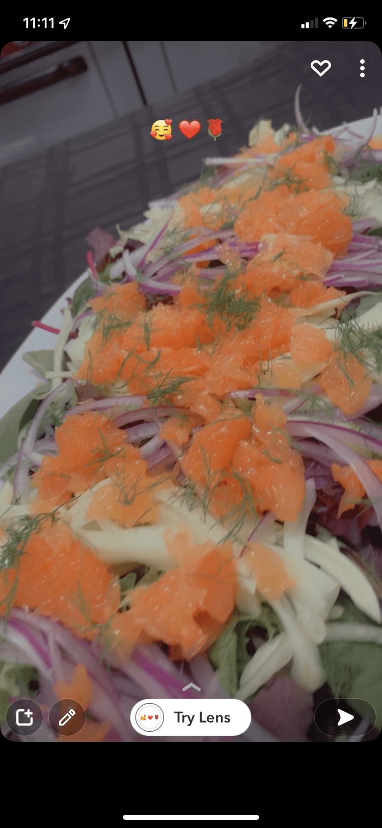 Close-up of a colorful sushi platter with orange, purple, and white ingredients on a green leaf, garnished with shredded vegetables.