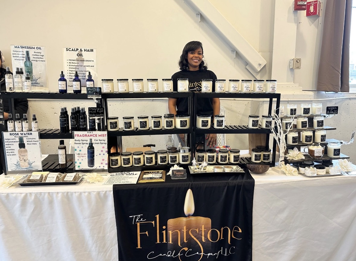 Child standing behind a display table with skincare products at The Flintstone skincare event.