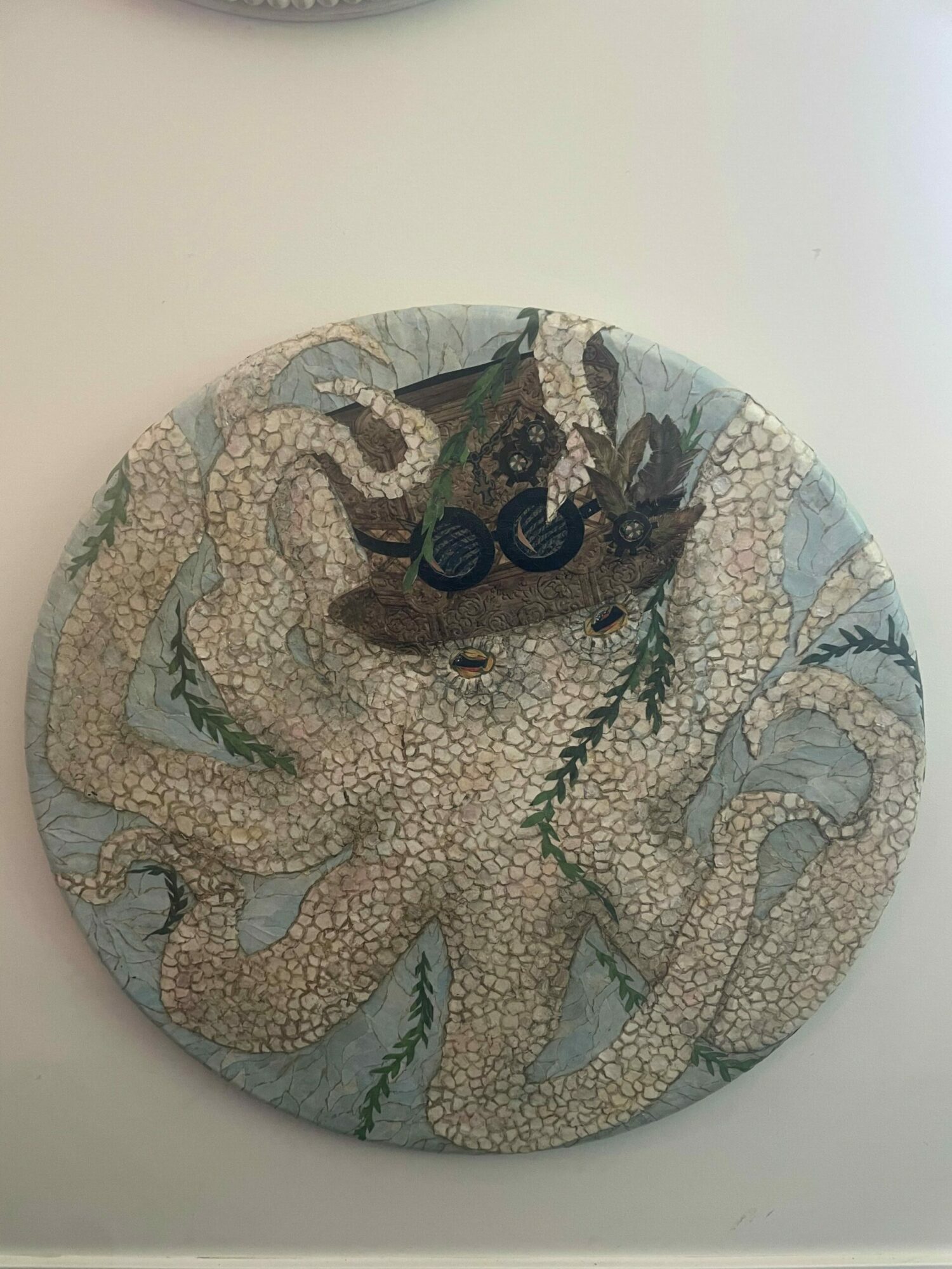 Circular mosaic artwork of an octopus with detailed tentacles and a textured background.