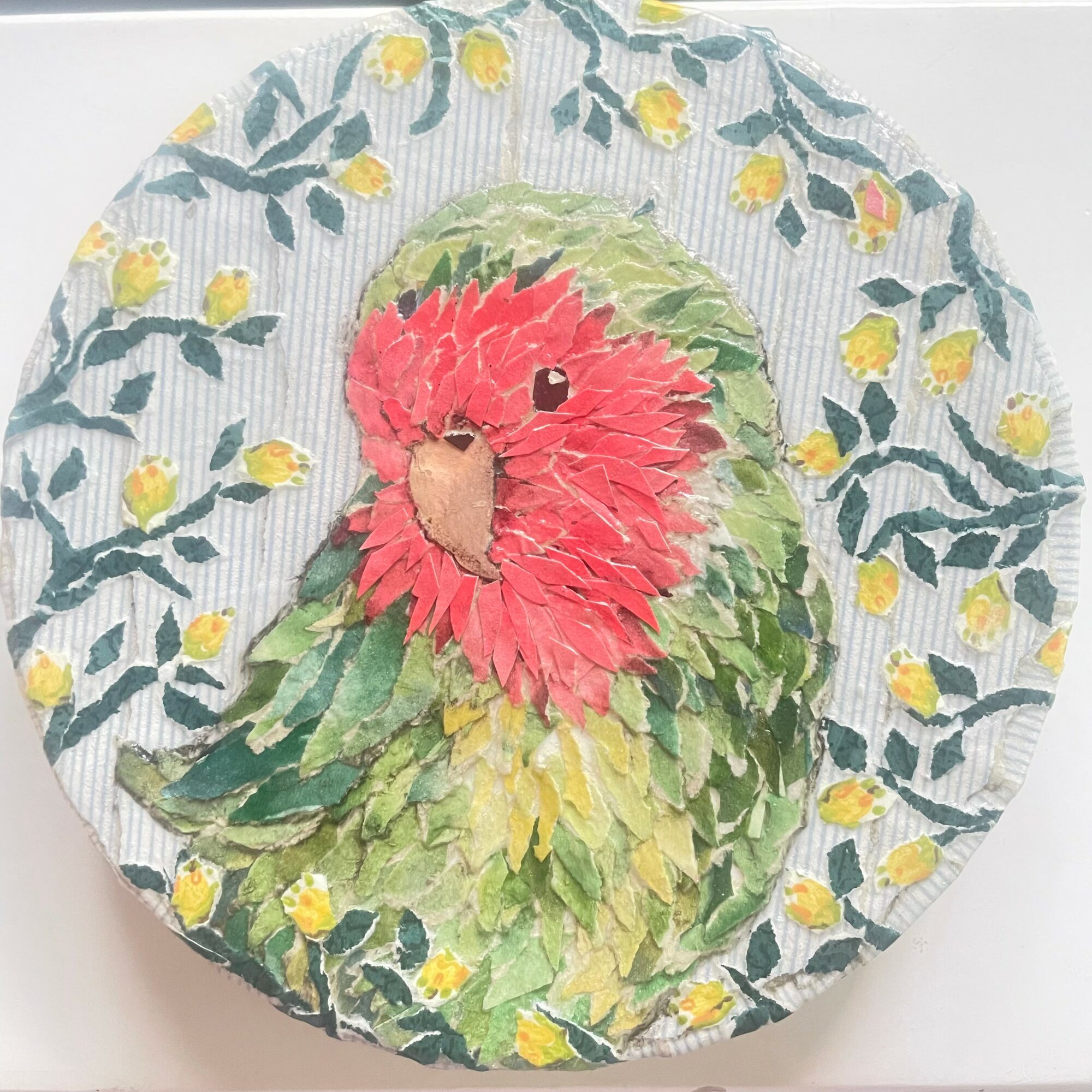 Watercolor painting of a green and red parrot surrounded by yellow flowers and green leaves.