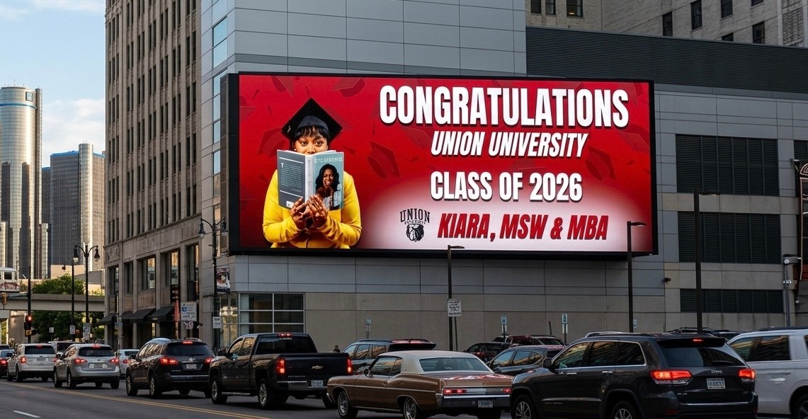 Digital billboard displays graduation congratulations for Union University Class of 2026, featuring a graduate holding a diploma, with city buildings in background.