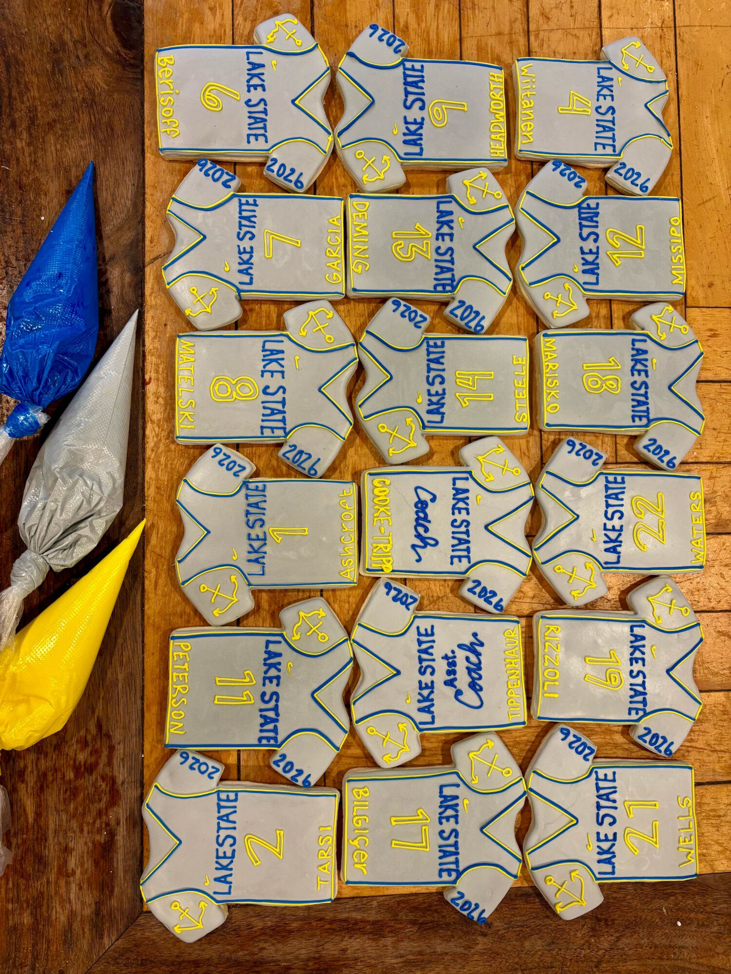 Multiple unopened Lake Stev juice boxes arranged on a wooden surface, with some plastic bags nearby.