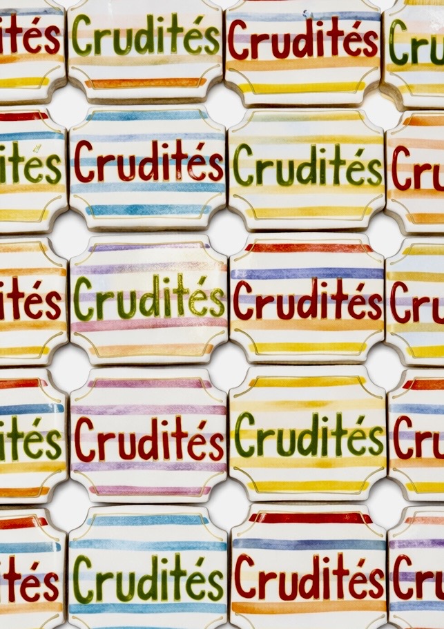 Multiple colorful packages of Cruditès snack crackers arranged in a grid pattern, with red, green, yellow, and blue text and stripes.