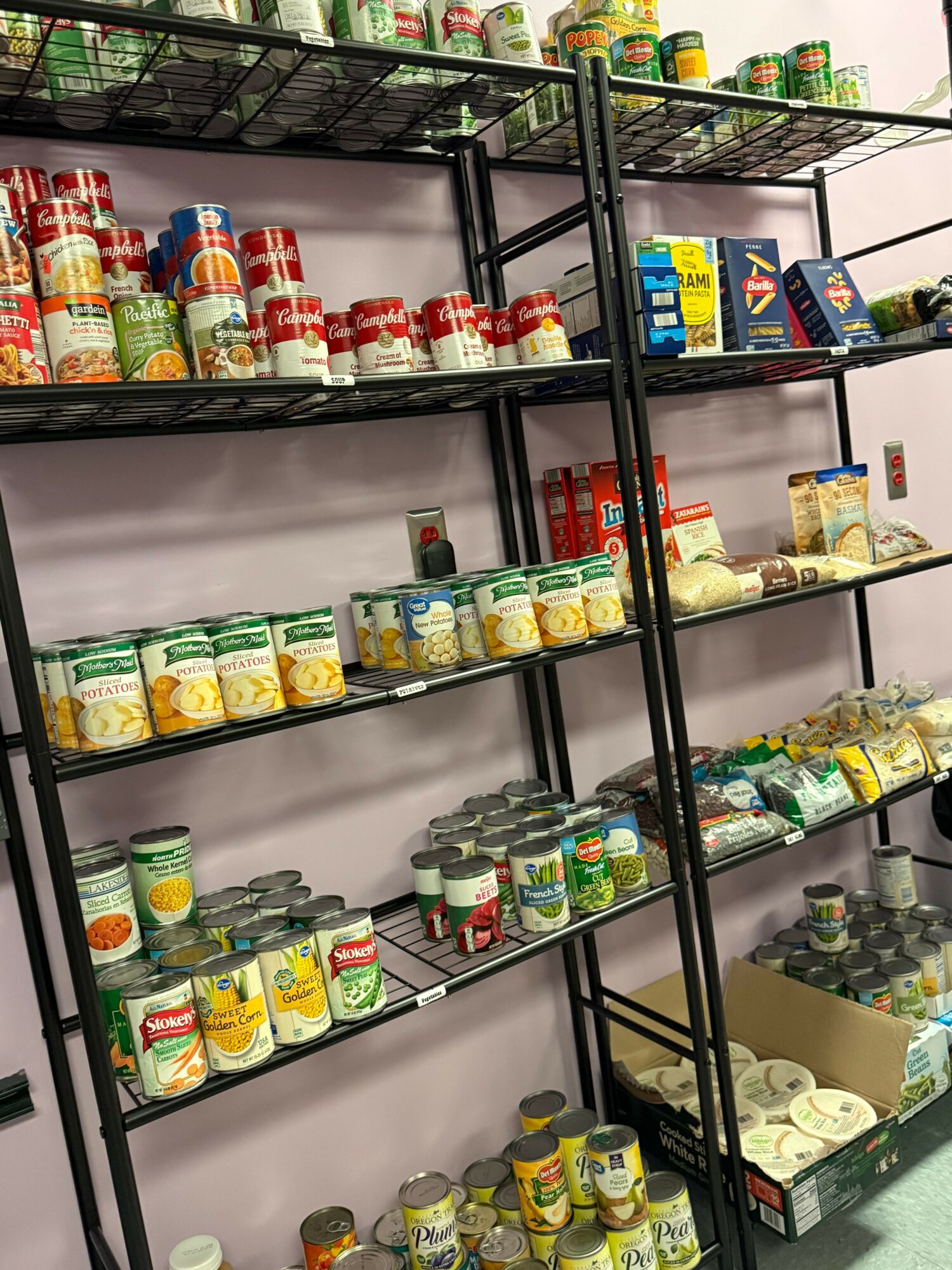 Empty store shelves with various canned and bottled goods, viewed from above, organized in rows and sections.