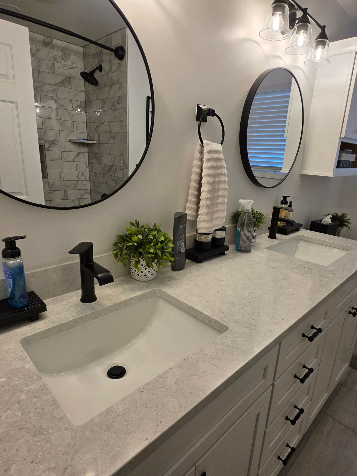 Bathroom countertop with sink, mirror, plants, and toiletries, viewed from the side. The image is rotated 90 degrees clockwise.