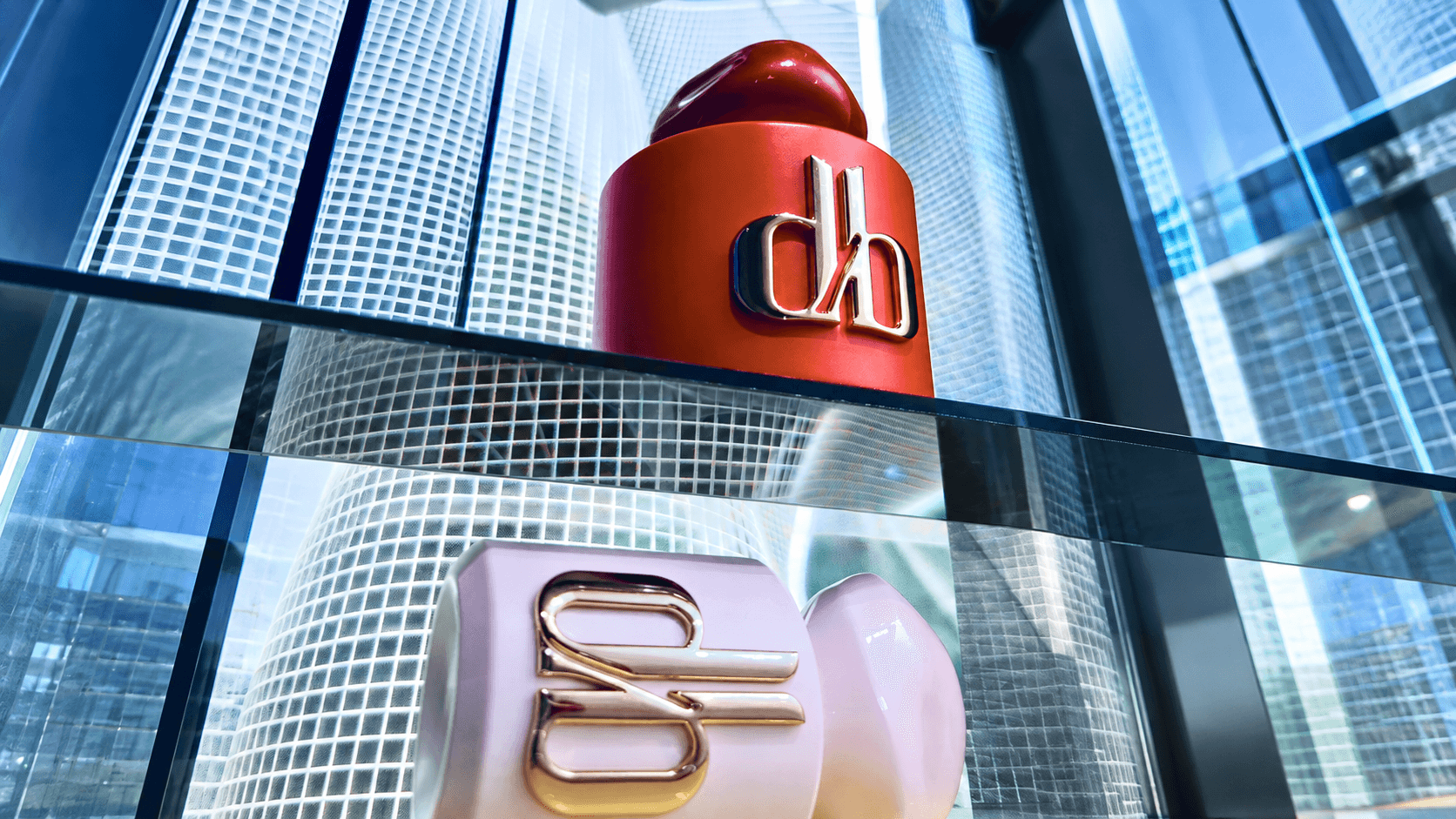 Tall building with a large red and white logo on the facade, glass windows reflecting the sky and surrounding structures.